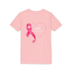 A light pink short-sleeve t-shirt with a pink ribbon and heart graphic on the front, featuring the text 'LETTY #TAKESAVILLAGE' in white, displayed on a clean white background.