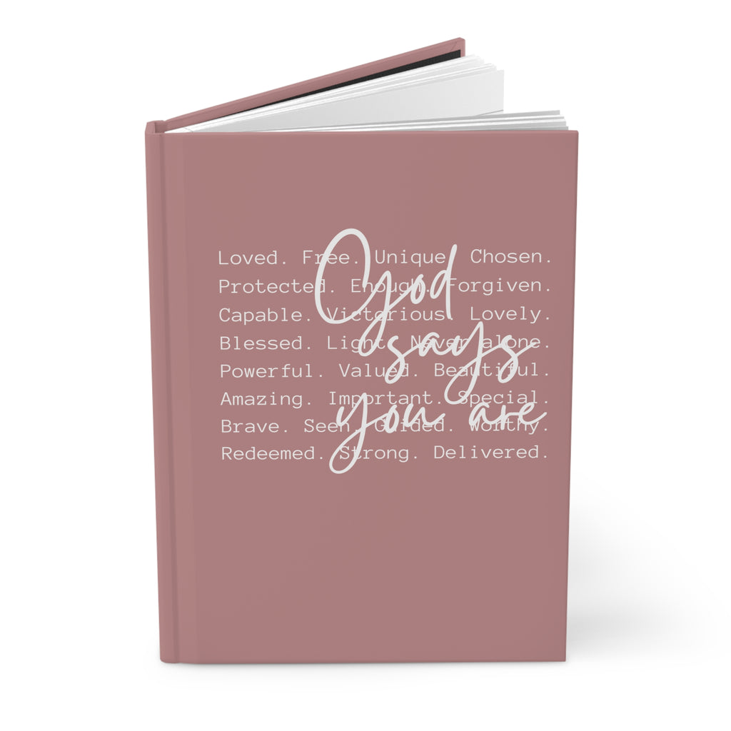 Pink notebook with motivational text on a white background